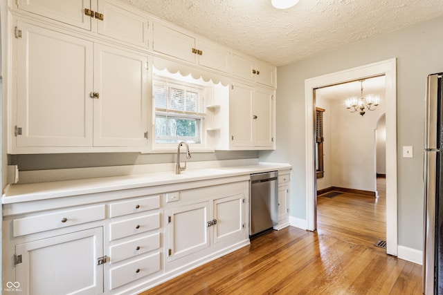 595 W Poplar St, Zionsville, IN 46077 - kitchen with stainless steel dishwasher, light wood-style floors, white cabinets, and a textured ceiling