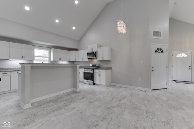 9317 E 36th Pl, Indianapolis, IN 46235 - kitchen with appliances with stainless steel finishes, high vaulted ceiling, light marble finish flooring, white cabinetry, and a center island