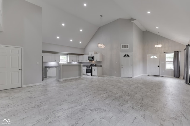 9317 E 36th Pl, Indianapolis, IN 46235 - unfurnished living room featuring high vaulted ceiling, healthy amount of natural light, light marble finish flooring, recessed lighting, and baseboards