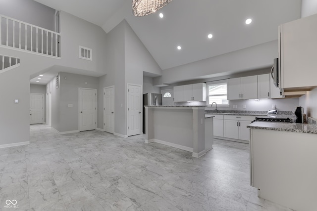 9317 E 36th Pl, Indianapolis, IN 46235 - kitchen with range, light marble finish floors, white cabinets, a sink, and high vaulted ceiling
