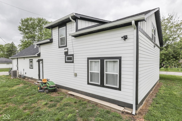 9317 E 36th Pl, Indianapolis, IN 46235 - view of property exterior featuring a lawn, board and batten siding, and central AC unit