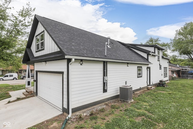 9317 E 36th Pl, Indianapolis, IN 46235 - view of side of property featuring cooling unit, roof with shingles, a lawn, and board and batten siding