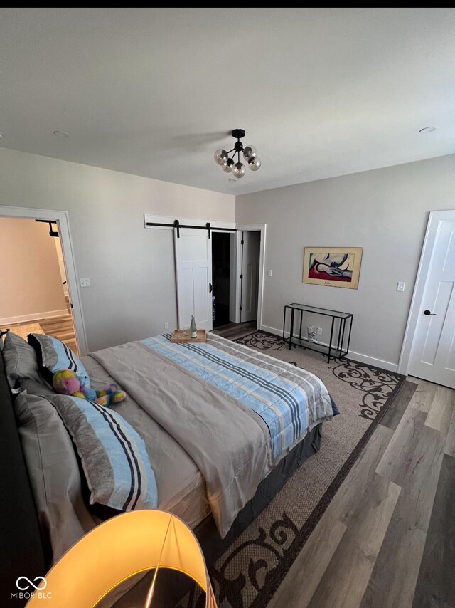 811 E Minnesota St, Indianapolis, IN 46203 - bedroom featuring wood finished floors, a barn door, and baseboards