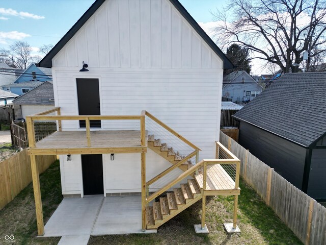 811 E Minnesota St, Indianapolis, IN 46203 - rear view of house with board and batten siding, a fenced backyard, stairway, a deck, and a patio