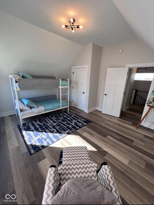 811 E Minnesota St, Indianapolis, IN 46203 - bedroom featuring lofted ceiling, baseboards, wood finished floors, and a chandelier