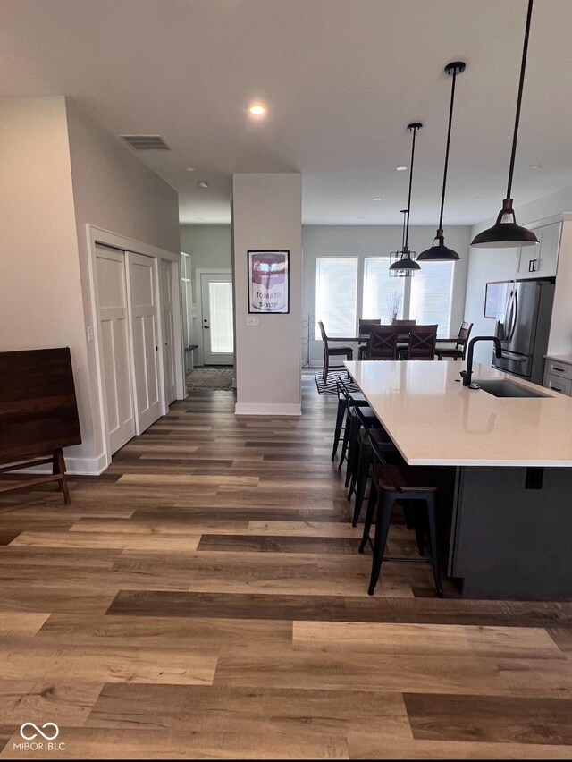 811 E Minnesota St, Indianapolis, IN 46203 - kitchen featuring stainless steel fridge, a sink, light countertops, white cabinetry, and a breakfast bar