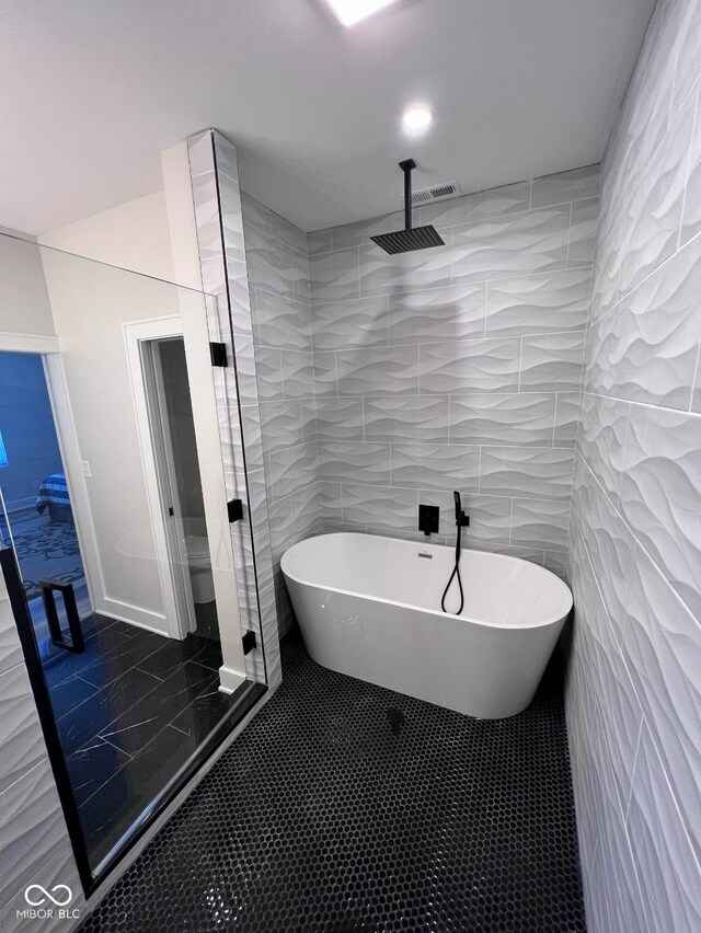 811 E Minnesota St, Indianapolis, IN 46203 - bathroom with a freestanding bath, a stall shower, tile walls, and tile patterned flooring