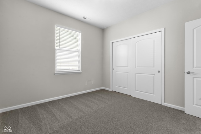 11815 Adair Pl, Indianapolis, IN 46229 - unfurnished bedroom featuring dark carpet, baseboards, and a closet