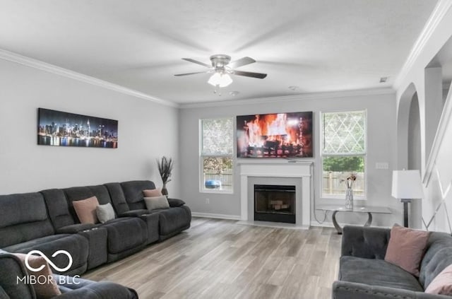 4689 Muscatine Way, Westfield, IN 46062 - living room with arched walkways, a ceiling fan, crown molding, wood finished floors, and a fireplace with flush hearth