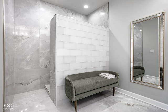 435 Virginia Ave Unit 106, Indianapolis, IN 46203 - bathroom featuring marble look tile flooring, a marble finish shower, and baseboards