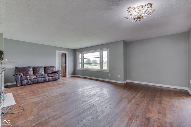 1601 Southern Ave, Beech Grove, IN 46107 - unfurnished living room with wood finished floors, baseboards, and a textured ceiling