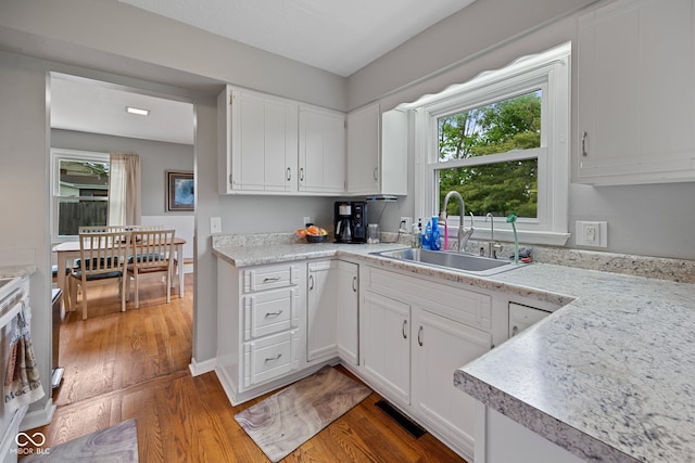 124 Knox Dr, West Lafayette, IN 47906 - kitchen with a sink, wood finished floors, light countertops, and white cabinets