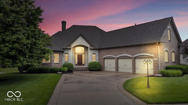 14711 Macduff Dr, Noblesville, IN 46062 - french country inspired facade with a shingled roof, brick siding, a front lawn, and a chimney