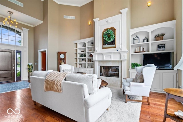 14711 Macduff Dr, Noblesville, IN 46062 - living room with a high ceiling, wood finished floors, crown molding, and a tile fireplace