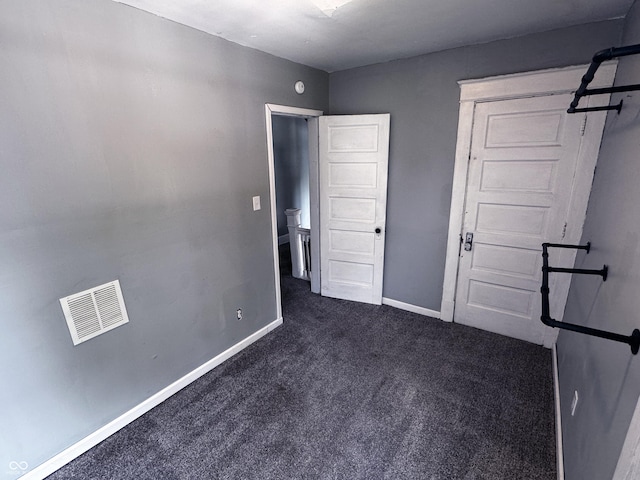 3502 N Kenwood Ave, Indianapolis, IN 46208 - unfurnished bedroom featuring dark carpet and baseboards