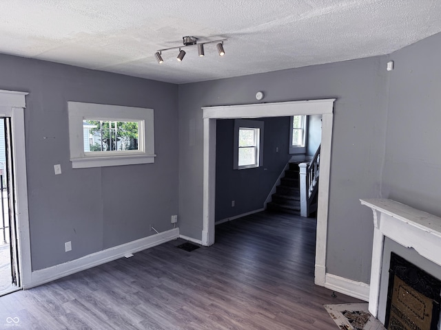 3502 N Kenwood Ave, Indianapolis, IN 46208 - unfurnished living room with wood finished floors, stairs, a fireplace with flush hearth, a textured ceiling, and baseboards