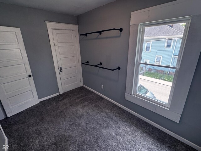 3502 N Kenwood Ave, Indianapolis, IN 46208 - unfurnished room featuring dark colored carpet, plenty of natural light, and baseboards
