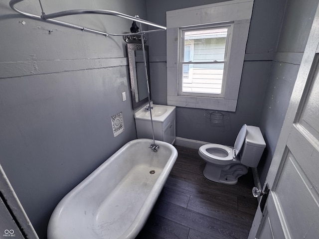 3502 N Kenwood Ave, Indianapolis, IN 46208 - bathroom with a soaking tub, wood finished floors, toilet, baseboards, and vanity