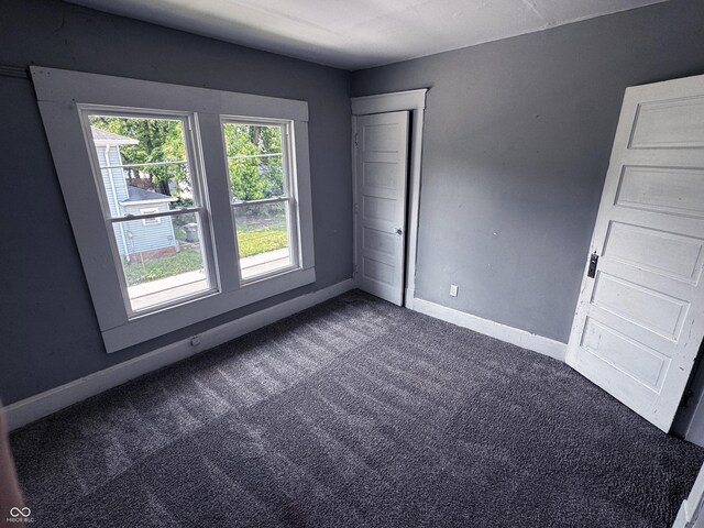 3502 N Kenwood Ave, Indianapolis, IN 46208 - spare room featuring dark carpet and baseboards