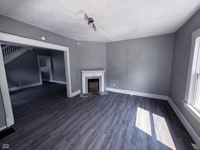 3502 N Kenwood Ave, Indianapolis, IN 46208 - unfurnished living room with a textured ceiling, baseboards, dark wood finished floors, and a fireplace with flush hearth