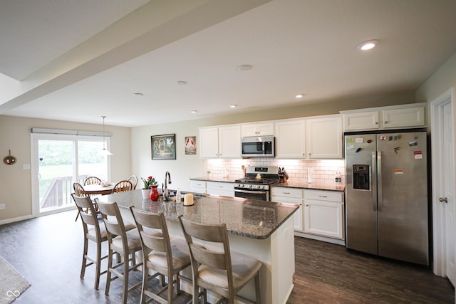 9903 Deep Royal Way, Indianapolis, IN 46239 - kitchen featuring stainless steel appliances, a sink, backsplash, dark stone counters, and a breakfast bar