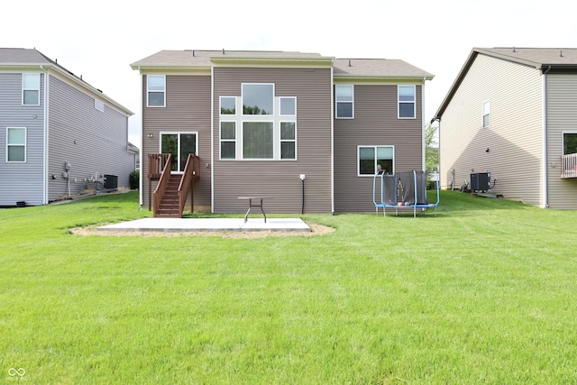 9903 Deep Royal Way, Indianapolis, IN 46239 - back of house with a trampoline, central AC, a patio area, and a lawn