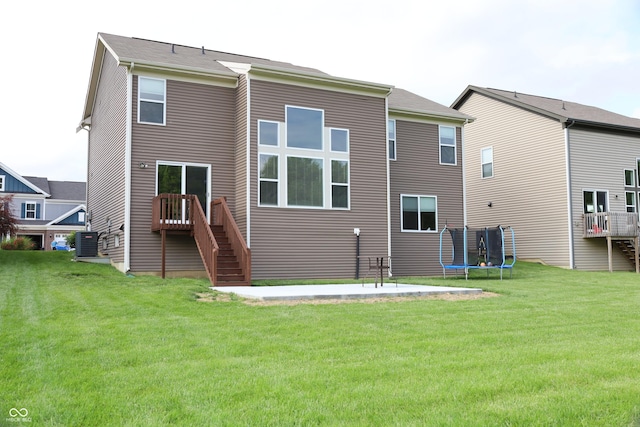 9903 Deep Royal Way, Indianapolis, IN 46239 - back of house featuring stairs, central AC unit, a trampoline, and a yard