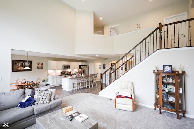9903 Deep Royal Way, Indianapolis, IN 46239 - carpeted living room with stairway, baseboards, a high ceiling, and recessed lighting