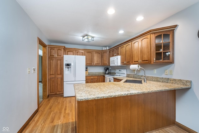 4399 Summerhaven Dr, New Palestine, IN 46163 - kitchen with white appliances, a peninsula, a sink, glass insert cabinets, and light wood finished floors