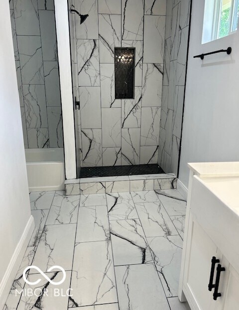 2936 Guilford Ave, Indianapolis, IN 46205 - full bath with marble look tiles, a marble finish shower, baseboards, vanity, and a bath