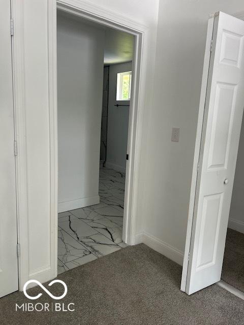 2936 Guilford Ave, Indianapolis, IN 46205 - hallway featuring marble look tile flooring and baseboards