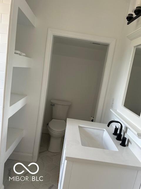 2936 Guilford Ave, Indianapolis, IN 46205 - bathroom featuring vanity, toilet, and tile patterned flooring