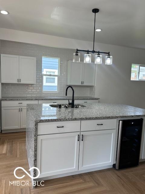 2936 Guilford Ave, Indianapolis, IN 46205 - kitchen with wine cooler, a sink, white cabinetry, plenty of natural light, and recessed lighting