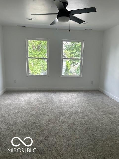 2936 Guilford Ave, Indianapolis, IN 46205 - carpeted empty room featuring plenty of natural light, baseboards, and a ceiling fan