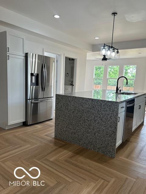 2936 Guilford Ave, Indianapolis, IN 46205 - kitchen featuring stainless steel fridge with ice dispenser, a sink, dishwasher, light stone countertops, and white cabinetry