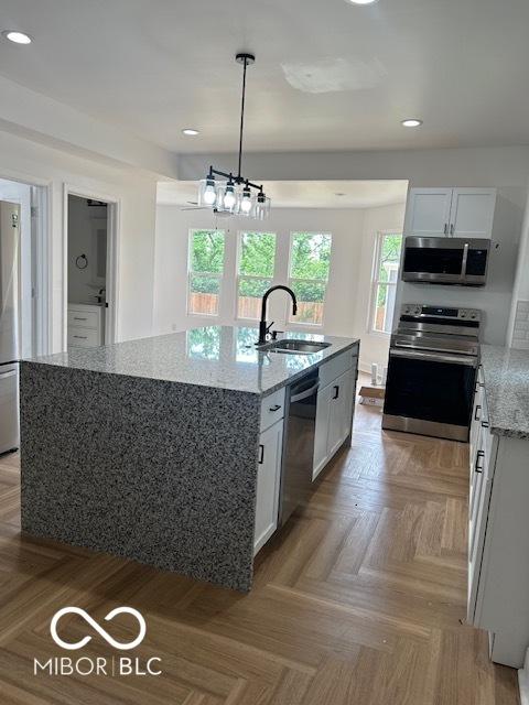2936 Guilford Ave, Indianapolis, IN 46205 - kitchen with a sink, appliances with stainless steel finishes, recessed lighting, light stone counters, and an island with sink