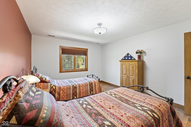 11875 W 700 S, Columbus, IN 47201 - bedroom featuring light wood-type flooring, baseboards, and a textured ceiling