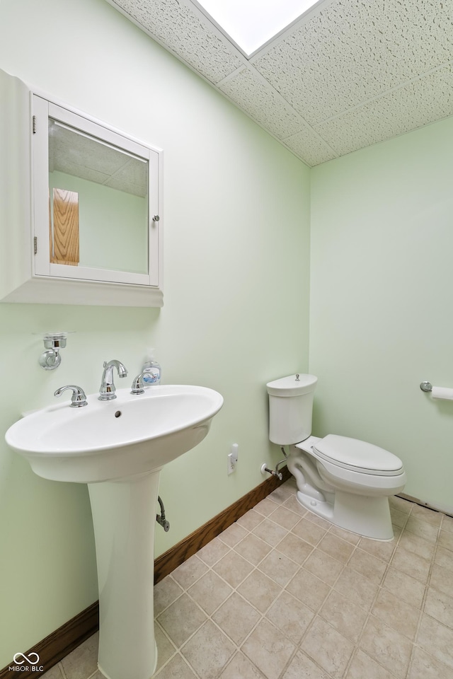 11875 W 700 S, Columbus, IN 47201 - bathroom with toilet, a sink, tile patterned floors, a paneled ceiling, and baseboards
