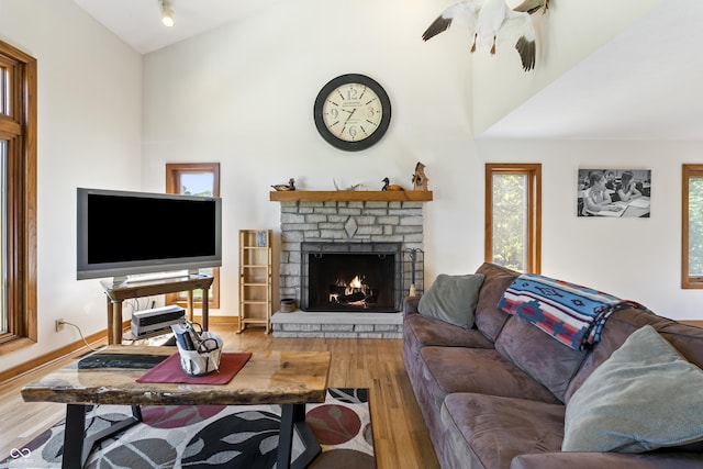 11875 W 700 S, Columbus, IN 47201 - living room with wood finished floors, a stone fireplace, plenty of natural light, a ceiling fan, and a high ceiling