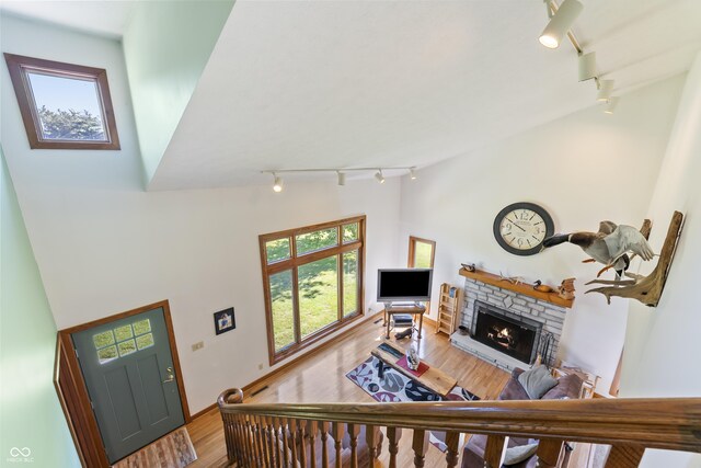 11875 W 700 S, Columbus, IN 47201 - living area featuring track lighting, wood finished floors, a fireplace, a towering ceiling, and baseboards