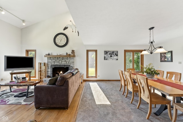 11875 W 700 S, Columbus, IN 47201 - living room featuring track lighting, a lit fireplace, light wood-style flooring, and baseboards