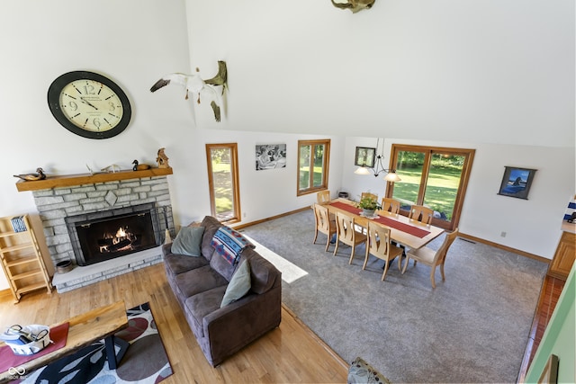 11875 W 700 S, Columbus, IN 47201 - living room featuring a stone fireplace, healthy amount of natural light, baseboards, light wood-style flooring, and high vaulted ceiling