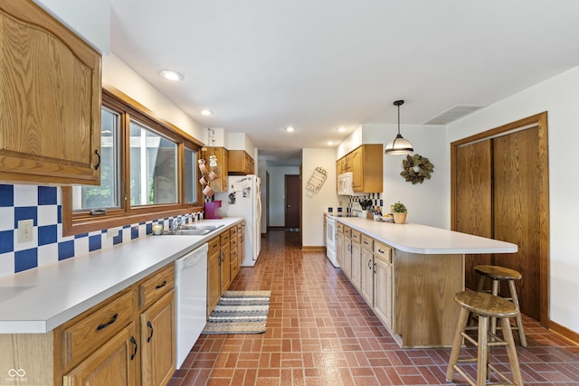 11875 W 700 S, Columbus, IN 47201 - kitchen with white appliances, a peninsula, brick patterned flooring, a kitchen bar, and light countertops