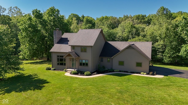 11875 W 700 S, Columbus, IN 47201 - view of front of home featuring a chimney, a front lawn, a shingled roof, and a wooded view