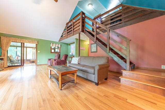 5821 Bittersweet Rd, Morgantown, IN 46160 - living room featuring stairs, wood finished floors, high vaulted ceiling, and baseboards