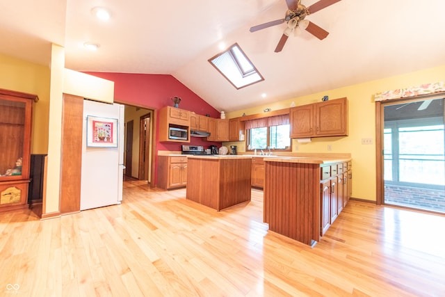 5821 Bittersweet Rd, Morgantown, IN 46160 - kitchen with stainless steel microwave, light countertops, light wood finished floors, a center island, and a skylight