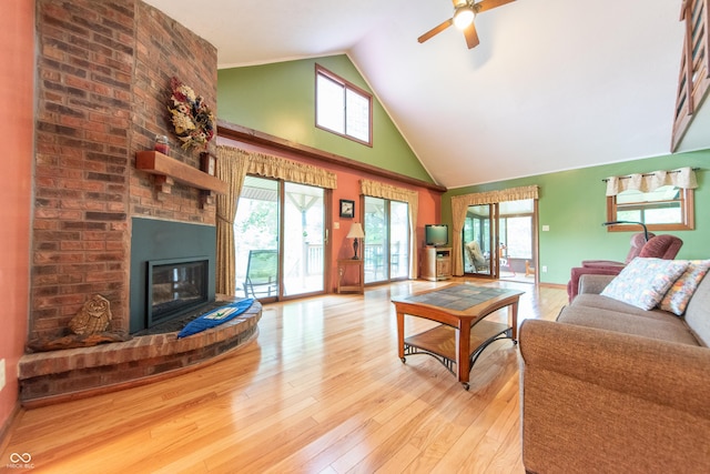 5821 Bittersweet Rd, Morgantown, IN 46160 - living room featuring a ceiling fan, light wood-style flooring, a fireplace, high vaulted ceiling, and baseboards