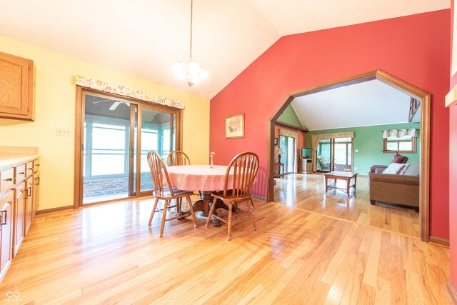 5821 Bittersweet Rd, Morgantown, IN 46160 - dining area with vaulted ceiling, light wood finished floors, a chandelier, arched walkways, and baseboards