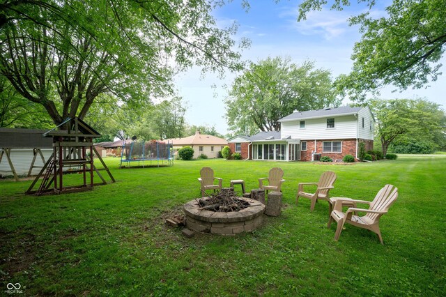 1495 E 240 N, Anderson, IN 46012 - view of grassy yard featuring a trampoline, a playground, a fire pit, and a sunroom