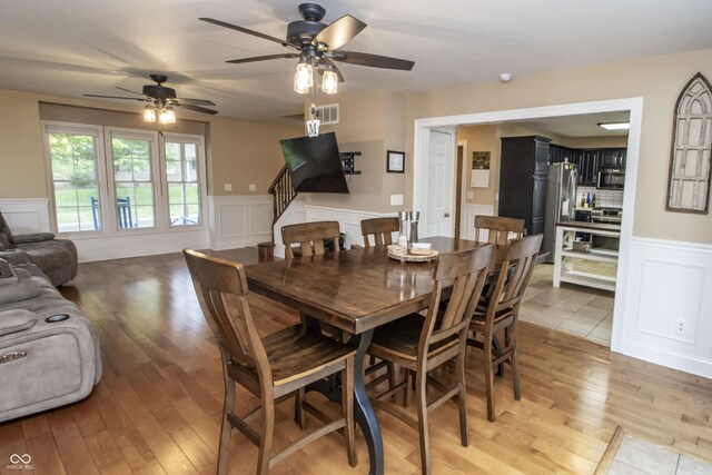 917 E Mill Creek Rd S, Greensburg, IN 47240 - dining area featuring a decorative wall, wainscoting, light wood-type flooring, a ceiling fan, and stairway